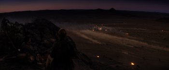 Movie still from “The Road Warrior” (1981), directed by George Miller – A person standing on top of a hill at night; Extreme Wide shot, High angle