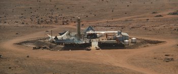 Movie still from “The Road Warrior” (1981), directed by George Miller – An aerial view of an oil rig in the middle of the desert; Extreme Wide shot, High angle
