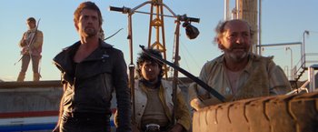 Movie still from “The Road Warrior” (1981), directed by George Miller – A group of men standing next to each other on top of a boat; Medium shot, Low angle