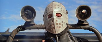 Movie still from “The Road Warrior” (1981), directed by George Miller – A person wearing a metal helmet and a metal mask; Close Up shot, Low angle