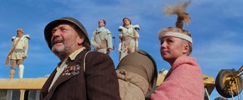 Movie still from “The Road Warrior” (1981), directed by George Miller – A group of people standing on top of a hill; Medium shot, Low angle
