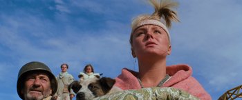 Movie still from “The Road Warrior” (1981), directed by George Miller – A woman and a dog are looking into the distance; Close Up shot, Low angle