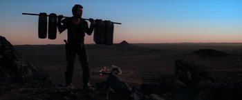 Movie still from “The Road Warrior” (1981), directed by George Miller – A man and a dog in the desert at night; Wide shot, Low angle