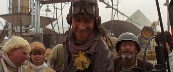 Movie still from “The Road Warrior” (1981), directed by George Miller – A man wearing a leather jacket and goggles; Close Up shot, Over the shoulder angle