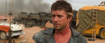 Movie still from “The Road Warrior” (1981), directed by George Miller – A person wearing a leather jacket; Close Up shot, Over the shoulder angle