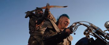 Movie still from “The Road Warrior” (1981), directed by George Miller – Two men in medieval garb holding bows and arrows; Medium shot, Low angle