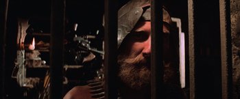 Movie still from “Mad Max Beyond Thunderdome” (1985), directed by George Miller – A man with a beard wearing a helmet; Close Up shot, Low angle