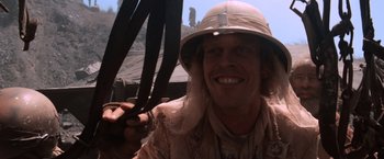 Movie still from “Mad Max Beyond Thunderdome” (1985), directed by George Miller – A man wearing a hat and holding a pair of scissors; Close Up shot, Low angle