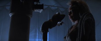 Movie still from “Mad Max Beyond Thunderdome” (1985), directed by George Miller – A woman standing next to a fire hydrant in the dark; Close Up shot, Low angle