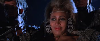 Movie still from “Mad Max Beyond Thunderdome” (1985), directed by George Miller – A person wearing a costume; Close Up shot, Over the shoulder angle