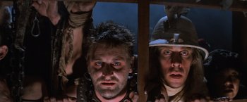 Movie still from “Mad Max Beyond Thunderdome” (1985), directed by George Miller – A group of men standing next to each other in a room; Close Up shot, Low angle
