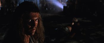 Movie still from “Mad Max Beyond Thunderdome” (1985), directed by George Miller – A person in a dark room; Close Up shot, Low angle