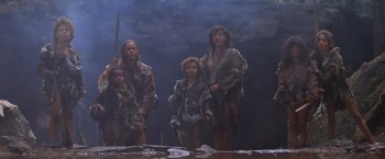 Movie still from “Mad Max Beyond Thunderdome” (1985), directed by George Miller – A group of people dressed in animal skins; Wide shot, Low angle