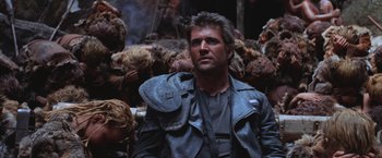 Movie still from “Mad Max Beyond Thunderdome” (1985), directed by George Miller – A man in a leather jacket is looking at the camera; Close Up shot, Low angle