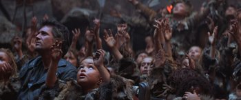 Movie still from “Mad Max Beyond Thunderdome” (1985), directed by George Miller – A group of people with their hands in the air; Medium shot, High angle
