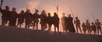 Movie still from “Mad Max Beyond Thunderdome” (1985), directed by George Miller – A group of people standing on top of a hill at sunset; Wide shot, Low angle