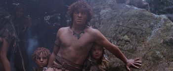 Movie still from “Mad Max Beyond Thunderdome” (1985), directed by George Miller – A man and a child are standing next to each other in the woods; Medium shot, Low angle
