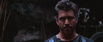 Movie still from “Mad Max Beyond Thunderdome” (1985), directed by George Miller – A person wearing a black shirt; Close Up shot, Low angle
