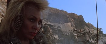 Movie still from “Mad Max Beyond Thunderdome” (1985), directed by George Miller – A person near a rock wall; Close Up shot, Low angle