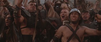 Movie still from “Mad Max Beyond Thunderdome” (1985), directed by George Miller – A group of people are gathered together in a crowd; Close Up shot, Low angle