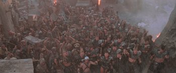 Movie still from “Mad Max Beyond Thunderdome” (1985), directed by George Miller – A large group of people are posing for a picture; Extreme Wide shot, High angle