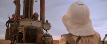Movie still from “Mad Max Beyond Thunderdome” (1985), directed by George Miller – A child sitting on the hood of an old fire truck; Wide shot, Over the shoulder angle