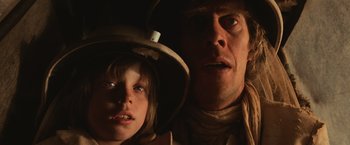 Movie still from “Mad Max Beyond Thunderdome” (1985), directed by George Miller – A man and a boy in a hat looking at the camera; Close Up shot, Low angle