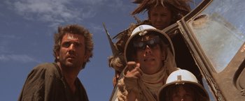Movie still from “Mad Max Beyond Thunderdome” (1985), directed by George Miller – A man with a hat and goggles on; Close Up shot, Low angle