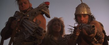 Movie still from “Mad Max Beyond Thunderdome” (1985), directed by George Miller – A woman in a wig and some other people; Close Up shot, Low angle