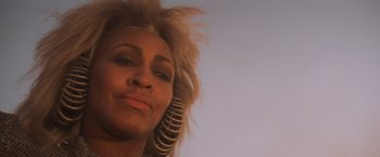 Movie still from “Mad Max Beyond Thunderdome” (1985), directed by George Miller – A person with a large hair piece; Close Up shot, Low angle