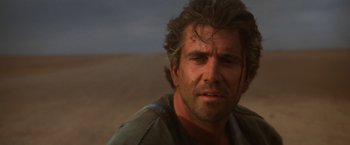 Movie still from “Mad Max Beyond Thunderdome” (1985), directed by George Miller – A person wearing a shirt; Close Up shot, Low angle