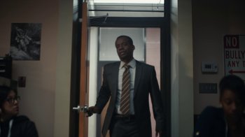Movie still from “Euphoria” (2019), created by Sam Levinson – A man in a suit and tie standing in front of an open door; Medium shot, Low angle