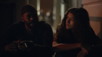Movie still from “Euphoria” (2019), created by Sam Levinson – A man and a woman sitting next to each other in the dark; Medium shot, Over the shoulder angle