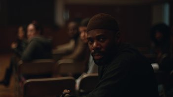 Movie still from “Euphoria” (2019), created by Sam Levinson – A man sitting in a room with other people; Close Up shot, Low angle