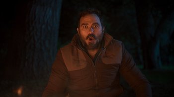 Movie still from “Mae Martin: SAP” (2023), directed by Abbi Jacobson – A man with a surprised look on his face in the dark; Close Up shot, Low angle