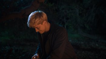 Movie still from “Mae Martin: SAP” (2023), directed by Abbi Jacobson – A man with blonde hair is listening to music; Medium shot, Over the shoulder angle