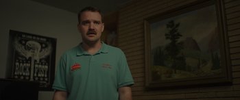 Movie still from “Maggie Moore(s)” (2023), directed by John Slattery – A man standing in front of a brick wall; Close Up shot, Low angle