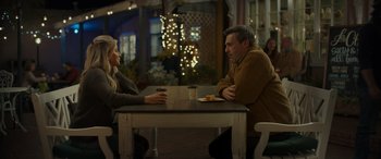 Movie still from “Maggie Moore(s)” (2023), directed by John Slattery – A man and a woman sitting at a table; Medium shot, Over the shoulder angle