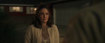 Movie still from “Maggie Moore(s)” (2023), directed by John Slattery – A woman standing in front of a mirror in a room; Close Up shot, Over the shoulder angle