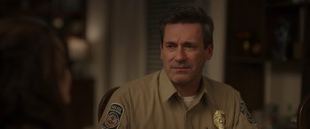 Movie still from “Maggie Moore(s)” (2023), directed by John Slattery – A police officer sitting in a chair with his eyes closed; Close Up shot, Over the shoulder angle