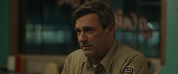 Movie still from “Maggie Moore(s)” (2023), directed by John Slattery – A person sitting in a room; Close Up shot, Over the shoulder angle