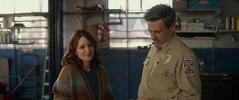 Movie still from “Maggie Moore(s)” (2023), directed by John Slattery – A man and a woman standing next to each other in a garage; Medium shot, Over the shoulder angle