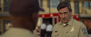 Movie still from “Maggie Moore(s)” (2023), directed by John Slattery – A man standing next to another man in front of a fire truck; Close Up shot, Over the shoulder angle