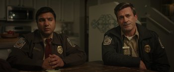 Movie still from “Maggie Moore(s)” (2023), directed by John Slattery – Two police officers sitting at a table in front of a refrigerator; Close Up shot, Over the shoulder angle