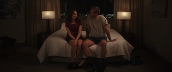 Movie still from “Maggie Moore(s)” (2023), directed by John Slattery – A man and a woman sitting on a bed; Medium shot, Over the shoulder angle