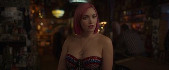 Movie still from “Maggie Moore(s)” (2023), directed by John Slattery – A woman with pink hair is posing for a picture; Close Up shot, Over the shoulder angle