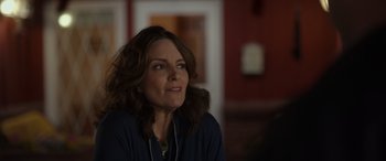 Movie still from “Maggie Moore(s)” (2023), directed by John Slattery – A person wearing headphones; Close Up shot, Over the shoulder angle