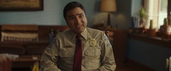 Movie still from “Maggie Moore(s)” (2023), directed by John Slattery – A man in a uniform is sitting in a chair; Close Up shot, Over the shoulder angle