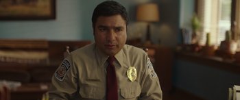 Movie still from “Maggie Moore(s)” (2023), directed by John Slattery – A man in a uniform sitting in front of a lamp; Close Up shot, Low angle