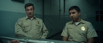 Movie still from “Maggie Moore(s)” (2023), directed by John Slattery – A couple of men sitting next to each other in a room; Medium shot, Low angle